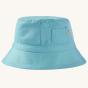 A closer view of the plain blue side of the reversible hat and pocket of the Frugi Children's Organic Cotton Rocky Reversible Hat - Stingray / Jawsome