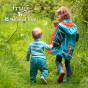 Young girl and boy walking through some long grass wearing the Frugi National Trust Beaver print puddler buster jacket