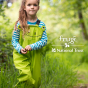Close up of young girl stood in long grass wearing the Frugi X National Trust frog print puddle buster trousers