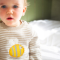 A baby wears the Frugi Knitted Outfit - Buzzy Bee.