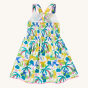 The back of the Frugi Organic Seraphina Dress - Jaguar Jungle, showing the cross over shoulder straps, inside lining and elasticated waistband, on a cream background