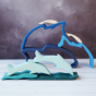 Wooden dolphin puzzle set in various shades of blue. The set includes a mixture of outlines and full-body shapes. In the background, the outline pieces are stacked together whilst in the foreground the full-body shapes are forming a dolphin diving scene.