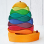 A wooden stacker set of various shapes, colours, and sizes of fish. The set includes a wooden boat with a sail on which the fish shapes are stacked to produce a uniform shape.