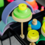 Grimm's Conical Stacking Tower - Neon Green - In a home environment. Grimm's Rainbows, Tower toys and Neon friends are also in the scene.