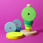 Grimm's Conical Stacking Tower - Neon Green - On a plain pink background. Alternative stacking layout. 