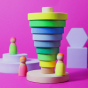 Grimm's Conical Stacking Tower - Neon Green - On a plain pink background. Grimm's Neon Mix Friends as well as other Grimm's wooden block toys are in the background.
