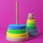 Grimm's Conical Stacking Tower - Neon Green - On a plain pink background. The toy is half stacked with the rest of the pieces laying to the side of the toy.