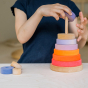 Grimm's Conical Stacking Tower - Neon Pink - A child plays alone with the stacking toy.