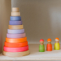 Grimm's Conical Stacking Tower - Neon Pink - On a plain cream background. Grimm's Neon Mix Friends are to the side of the toy