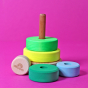 Grimm's Small Conical Stacking Tower - Neon Green - On a plain pink background. Some of the pieces are separated, whilst the others are stacked on the base.