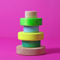 Grimm's Small Conical Stacking Tower - Neon Green - On a plain pink background. Alternative puzzle layout.