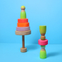 Grimm's Small Conical Stacking Tower - Neon Pink - On a plain blue background. Grimm's Neon Green Friends are in front and on top of the Tower. The puzzle has an alternative layout.