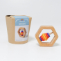 Grimm's Wooden Hexagon Baby Rattle next to its cardboard packaging on a grey background