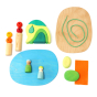 Pieces of the Grimm's plastic-free small world toy set laid out on a white background