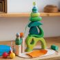 Grimm's plastic-free wooden toy blocks stacked in a tower on a wooden worktop