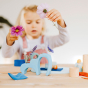 Young girl playing with some flowers and the Grimm's plastic-free wooden Waldorf toy blocks