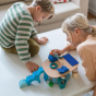 2 children sat down building a toy scene with the Grimm's Waldorf toy blocks