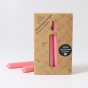 A pack of 12 Old Rose 10% beeswax candles by Grimm's with two pink candles outside the box. White background.