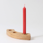 A Red 10% beeswax candle by Grimm's in a brass holder and celebration ring. White background