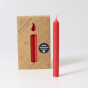 A pack of 12 Red 10% beeswax candles by Grimm's with a single red candle out of the cardboard box. White background
