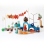 Grimm's wooden small world play toy set on a white background with some leaves, pinecones and conkers