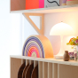 Grimm's 10-Piece Rainbow - Neon Pink- Sits on a shelf in a home setting.