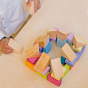 Grimms Wooden Pastel Duo Blocks being built into a circular wall by a child