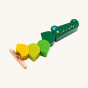 Haba Wooden Crocodile Threading Game. A fun threading game with vibrant green blocks in different shades of green, and a fun smiling crocodile head block attached to a yellow elasticated cord with a wooden stopper, on a cream back ground