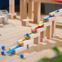 The HABA Wooden Melodious Marble Run. The image shows wooden blocks with musical metal keys stacked together and 2 marbles rolling down to make music