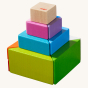A colourful pyramid tower made with the HABA Tangram Blocks, on a cream background