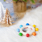 Heimess Touch Ring Rainbow Beads wooden clutching toy pictured on a white fluffy rug