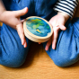 Close up of childs hands holding the Hellion Toys sustainable wooden solar circles