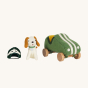 Olli Ella Holdie Dog-go Racer Boy sat next to a green felt racing car with wooden wheels and white stripes, and a green and white felt racing hat on a cream background