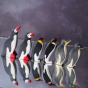 Holztiger, Bumbu and Ostheimer penguin figures lined up placed on a reflective surface 