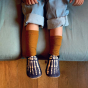 Child wearing Inch Blue Leather Baby Shoes - Bones with tan socks and jeans