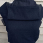 Integra eco-friendly black linen baby carrier in front of a wooden fence