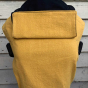 Integra ochre linen baby carrier in front of a white wooden fence 