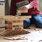 Close up of a child stacking some wooden Kapla building planks into a tower
