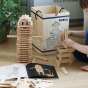 Child crouched down building a tower with Kapla Waldorf building blocks