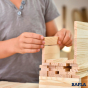 Close up of a child's hands stacking some Kapla wooden building blocks