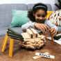 Girl stacking the Kapla plastic-free wooden toy blocks into the shape of a spider on a wooden table