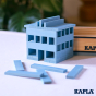 Close up of a wooden house made from Kapla plastic-free wooden blocks on a white table