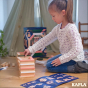 A child building a simple square stack using the blocks from the KAPLA 200 Box wooden building planks in Spring colours