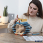 Close up of woman stacking the Kapla Waldorf toy blocks into the shape of an owl on a wooden table