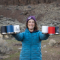 An adult holding a collection of Klean Kanteen Camping mugs with a hilly background