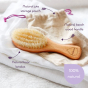 Close up of the Kokoso natural wooden baby brush on its jute pouch with purple annotations around the edge