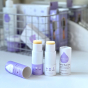 Kokoso unfragranced and lavender scented organic baby balm sticks on a white background in front of a crate of Kokoso baby products