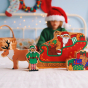Lanka Kade elf, presents and reindeer stood on a white sheet next to the Lanka Kade father christmas in a sleigh toy