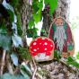Close up of the Lanka kade handmade wooden toadstool and hermit figure on some tree bark next to ivy leaves