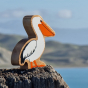 Close up of the Lanka Kade white pelican figure sat on a rock in front of the sea
